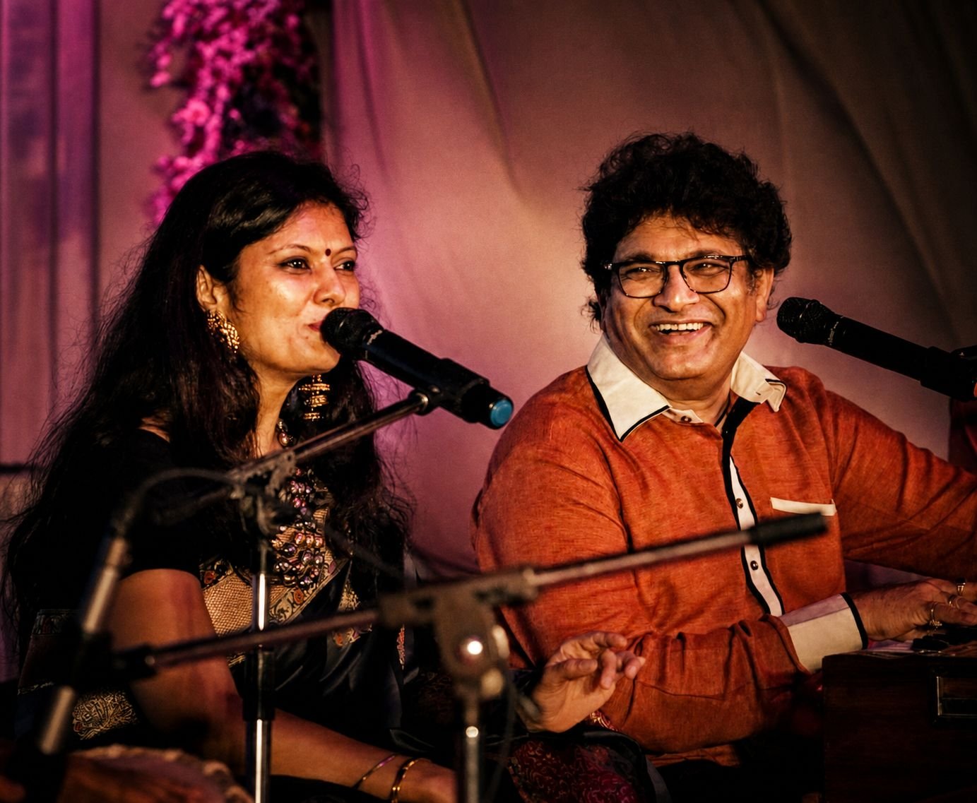 Sanjyot and Sanjay Banubakode singing together on stage, both smiling