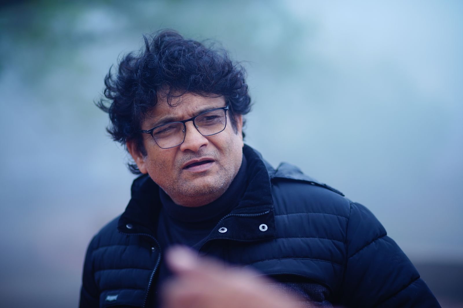 Sanjay Banubakode in a navy jacket on a misty morning, looking away from the camera