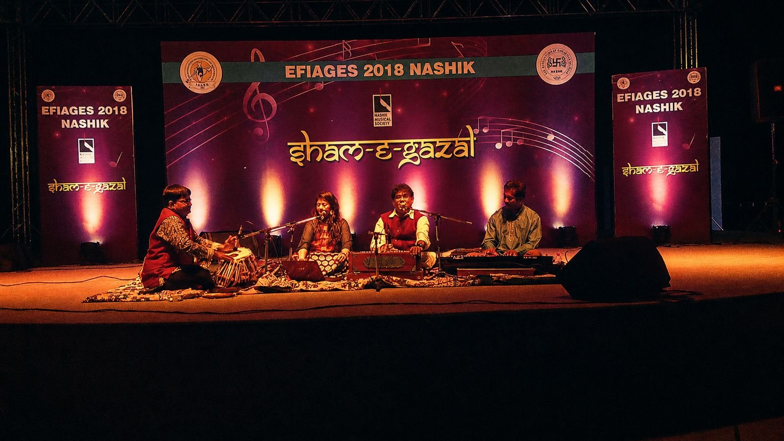 Sham-e-Ghazal at EFIAGES 2018, Nashik: ensemble on stage beneath the conference backdrop