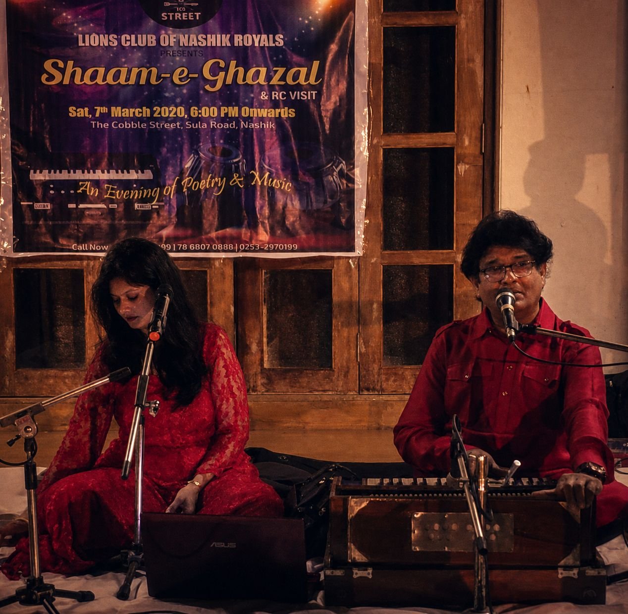 Shaam-e-Ghazal for the Lions Club of Nashik Royals, March 2020: Sanjay and Sanjyot on stage beneath the banner