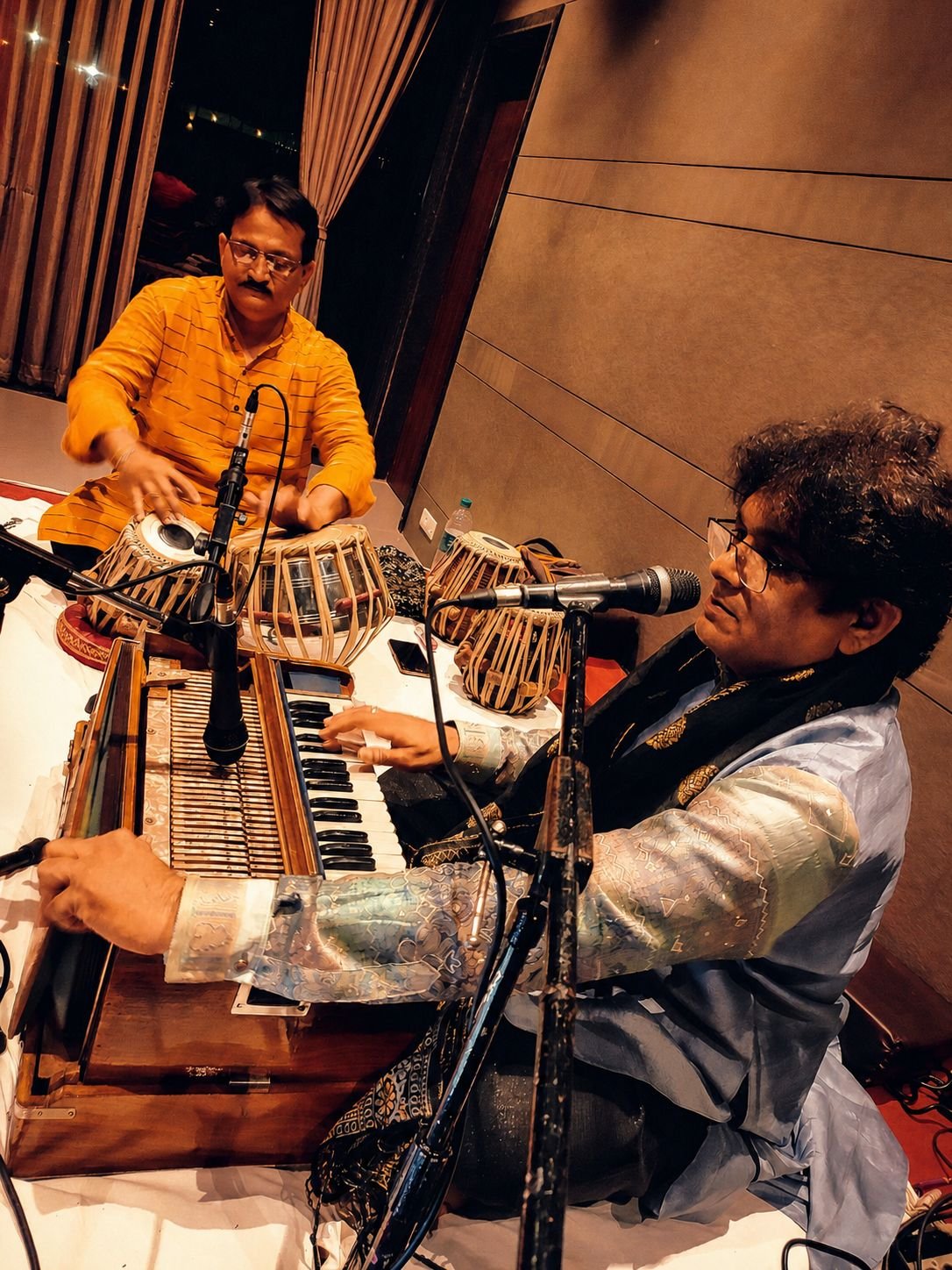 Seen from above: Sanjay Banubakode's hands on the harmonium keys, tabla player beside him