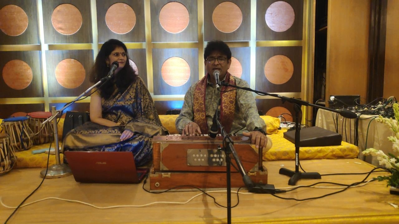 Sanjay and Sanjyot Banubakode performing in front of a wall of wooden discs